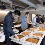 students getting pizza from boxes